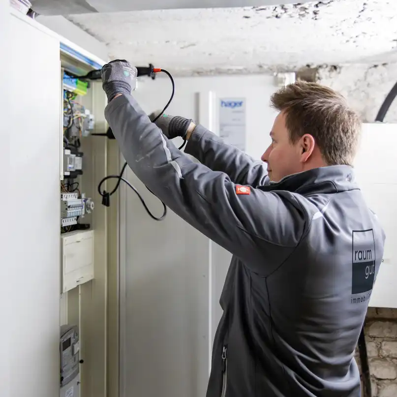 Ein Elektriker an einem Sicherungskasten